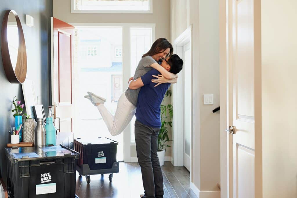a couple moving into their new home, they are cuddling.