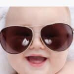 Baby wearing sunglasses, smiling. Text above: "Baby’s Smile Quotes and Beautiful Words for Instagram." Bottom corner text: "Read More.