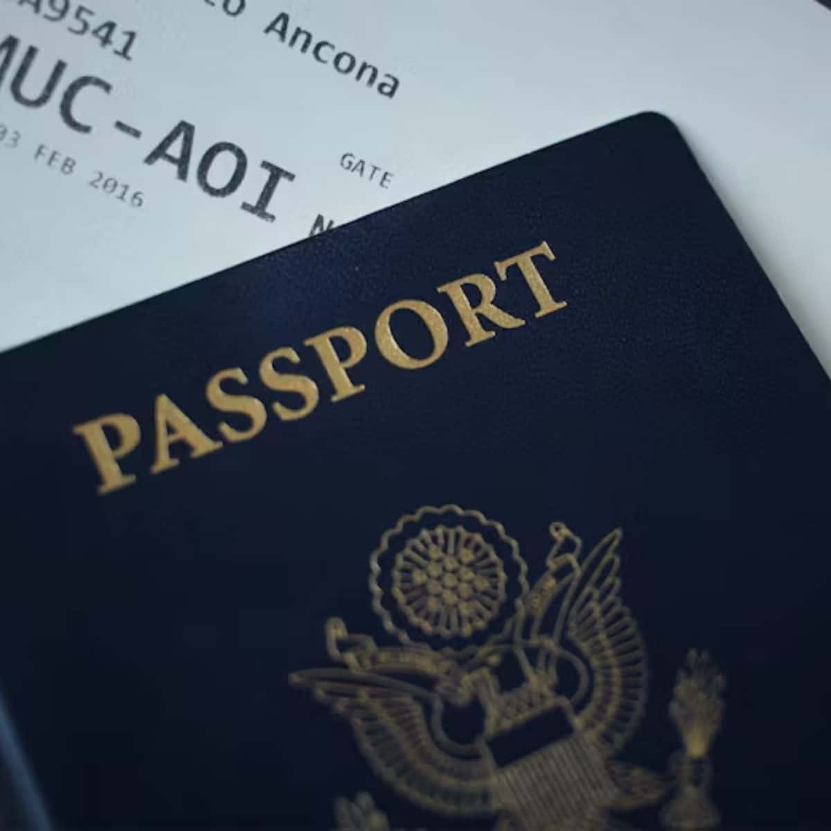 A close-up of a dark blue US passport partially covering a boarding pass.